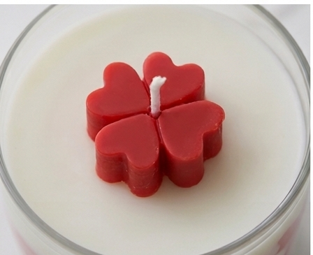 Top view of the hand-sculpted crimson clover bloom on ivory wax