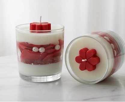 Two Crimson Clover candles styled together on a marble surface